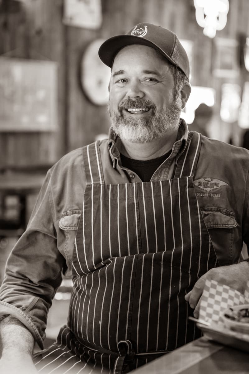 a guy in a striped apron with a baseball cap