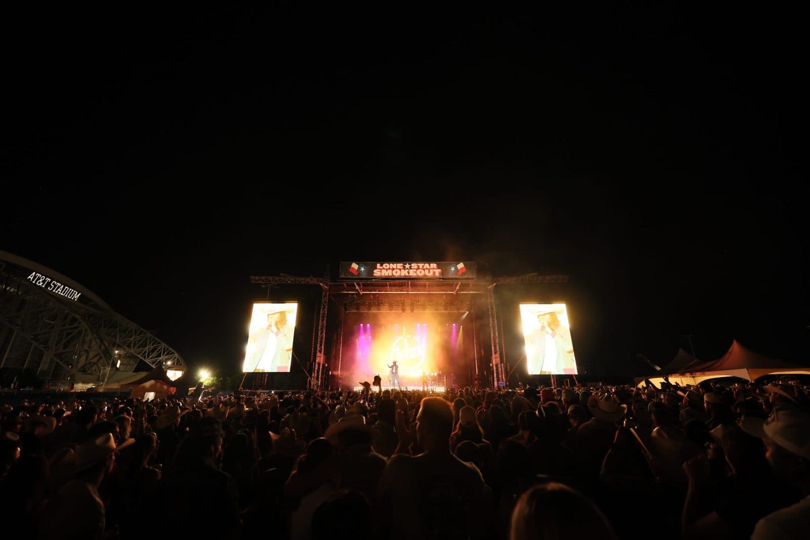 large crowd looking at a brightly lit main stage